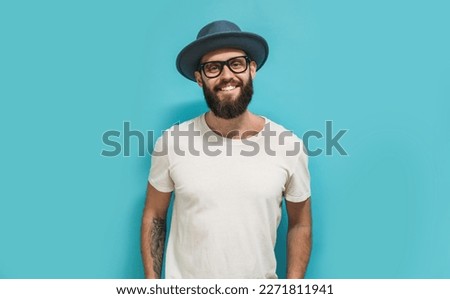 Young bearded hipster guy wearing white blank t shirt with copy space for your text or logo. Mockup for design