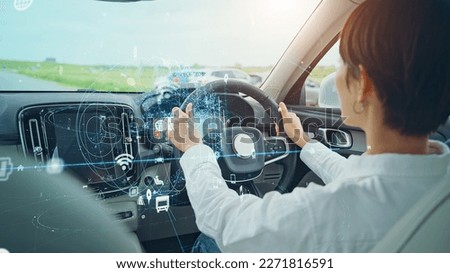 Woman driving a car and automotive technology concept. Driver assistant system. ITS (Intelligent Transport Systems). Mobility as a service. Royalty-Free Stock Photo #2271816591