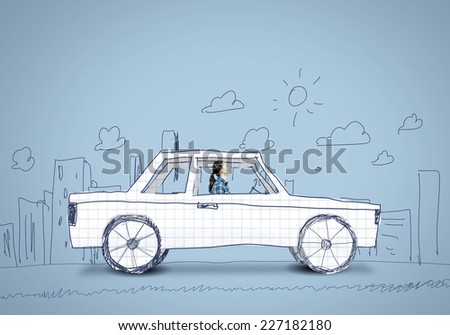 Young girl driving car made of paper
