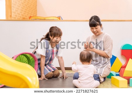 A babysitter woman working at a nursery school, daycare center, or children's center Royalty-Free Stock Photo #2271827621