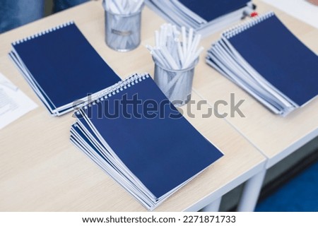 Gift bag package for conference participants before start, with a leaflet handout, notebook notepad, mug, pen, pencil, corporate gifts and souvenirs for employees of the company, office gift giving Royalty-Free Stock Photo #2271871733