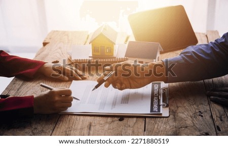 Real estate broker agent presenting and consult to customer to decision making sign insurance form agreement, buy and sell home model, concerning mortgage loan offer for and house insurance