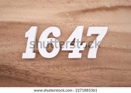 White number 1647 on a brown and light brown wooden background.