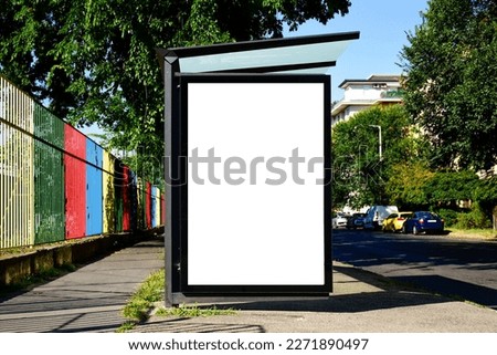 bus shelter at busstop. blank white lightbox. empty billboard and ad placeholder. glass and aluminum structure. transit station. urban setting. city street background. stone sidewalk. base for mockup Royalty-Free Stock Photo #2271890497