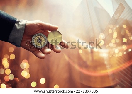 man in suit holding golden compass on background