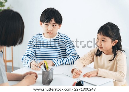Children being taught by a teacher. Cram school. School childcare. Royalty-Free Stock Photo #2271900249