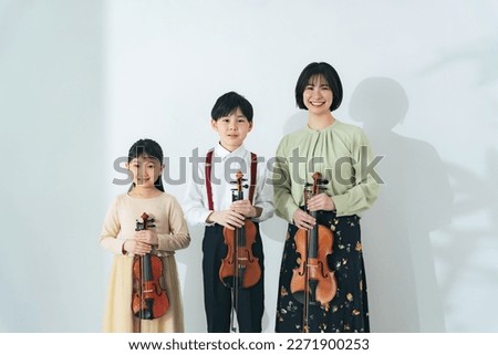 Woman and children with violins. violin class. Royalty-Free Stock Photo #2271900253