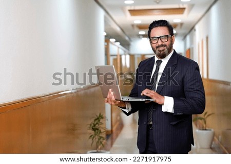 Indian businessman using laptop at office. Royalty-Free Stock Photo #2271917975