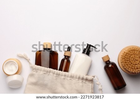 Preparation for spa. Compact toiletry bag and cosmetic products on white background, flat lay. Space for text Royalty-Free Stock Photo #2271923817