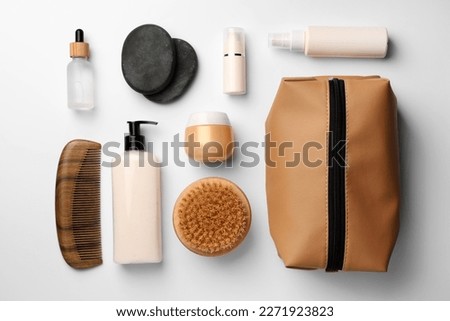 Compact toiletry bag, cosmetic products, comb and spa stones on white background, flat lay Royalty-Free Stock Photo #2271923823