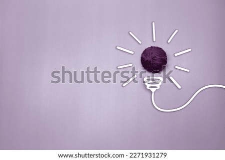 Creative thinking ideas and innovation concept. A purple color ball threads with a light bulb symbol on a violet background