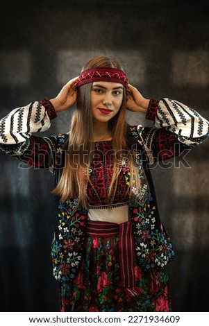 Pretty caucasian lady wear ethnic style embroidered shirt as traditional Ukrainian clothes against dark background. Ukraine handmade