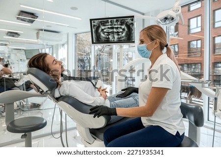 Dentist and patient choose treatment during consultation with medical equipment in dentistry. the right solution for the treatment of the oral cavity Royalty-Free Stock Photo #2271935341