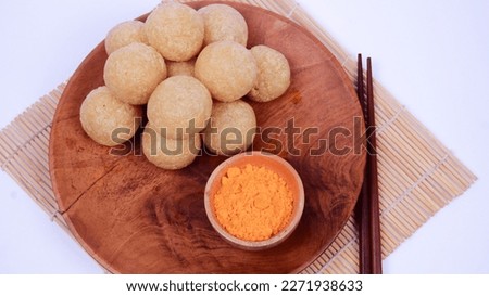 round tofu with the addition of spicy seasonings, there is also a brown wooden cutting board, chopsticks and a plain white background, the picture is right above the product