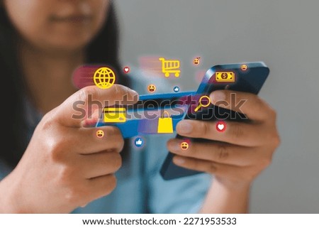 Woman using smart phone and credit card paying for online shopping with virtual graphic icons. Mobile payment with wallet app technology. Digital banking, e-commerce and financial technology concept.