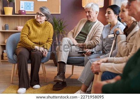 Full length view at group of elderly people watching TV in retirement home together Royalty-Free Stock Photo #2271958095