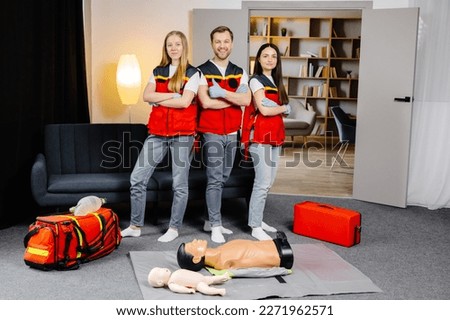 Group of people with cpr dummy looking at camera and smiling after first aid training class. Royalty-Free Stock Photo #2271962571