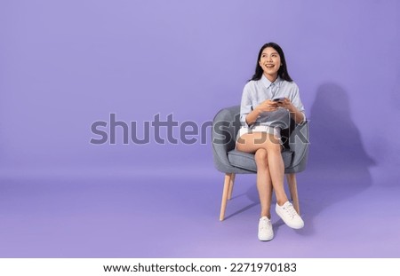 image of girl sitting on sofa  isolated on purple background Royalty-Free Stock Photo #2271970183