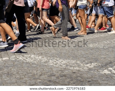 Many people walking in the city center of Porto. Pedestrians crossing the busy street on the pedestrian crossing in the city center of Porto, Portugal