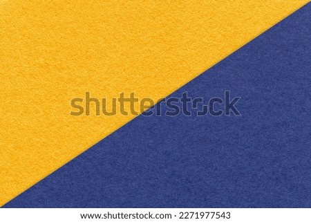 Texture of craft yellow and navy blue paper background, half two colors, macro. Structure of vintage dense kraft golden cardboard. Felt abstract backdrop closeup. Royalty-Free Stock Photo #2271977543