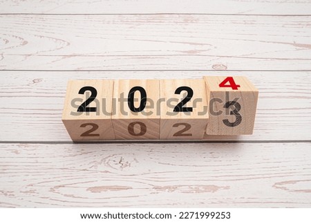 Business planning and countdown to 2024. Flipping 2023 to 2024 on wooden cubes on a wooden table