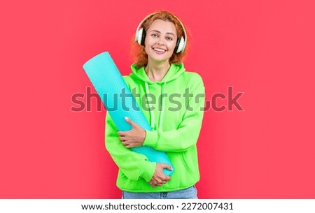 photo of happy fitness woman with yoga mat in headphones. fitness woman with yoga mat
