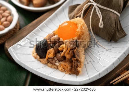 Zongzi. Rice dumpling for Chinese traditional Dragon Boat Festival (Duanwu Festival) on green leaf background with ingredient.