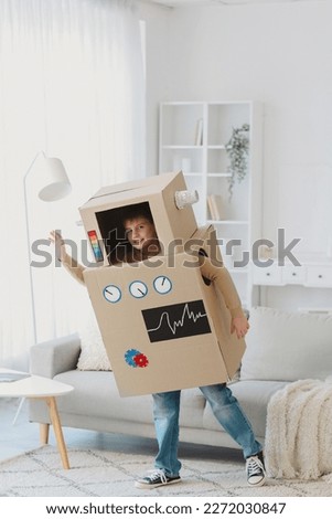 Little boy in cardboard robot costume playing at home Royalty-Free Stock Photo #2272030847