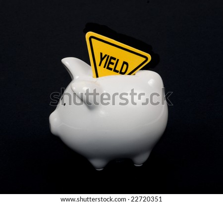 Piggy bank isolated on black with Yield sign in slot