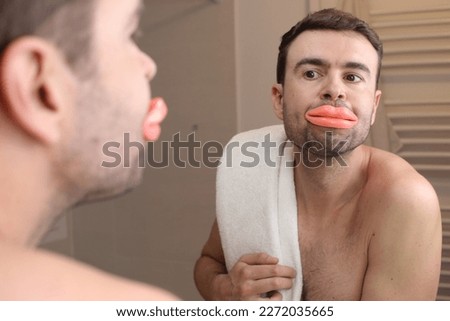 Comedic image of man looking at his enlarged lips  Royalty-Free Stock Photo #2272035665
