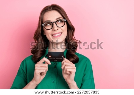 Photo of charming positive agent girl arms hold plastic debit card look empty space isolated on pink color background