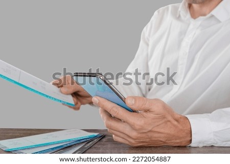Closeup photo of traveling man searching flight schedule for international travel in the studio on a light gray background
