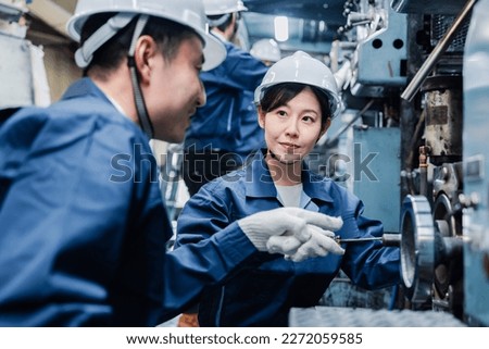Foreign workers being taught how to work at the factory Royalty-Free Stock Photo #2272059585