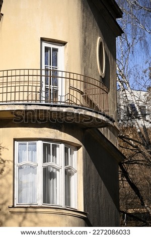 a rounded corner of a historic building with a wrap-around balcony