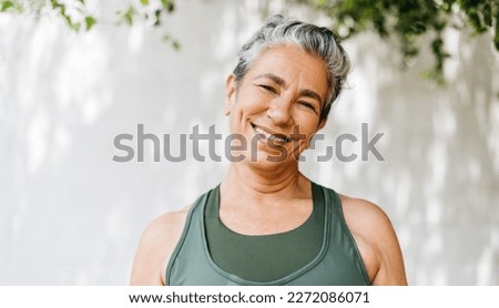 Mature woman looking at the camera with a happy smile as she takes on her outdoor workout routine in the morning. Retired woman staying healthy and active by adding regular exercise to her lifestyle. Royalty-Free Stock Photo #2272086071