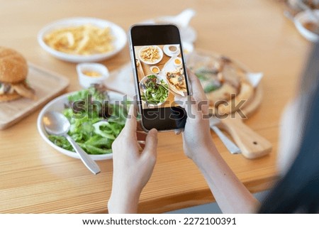Woman take picture of a meal on the table after ordering food online to eat at home. Photography and use phone concepts