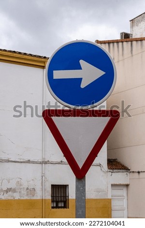 Vertical yield sign along with mandatory right turn sign above.