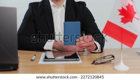 Canadian man consular officer showing passport immigrant, work visa, citizenship. Visa Application online form immigration concept. Visa approval. Royalty-Free Stock Photo #2272120845