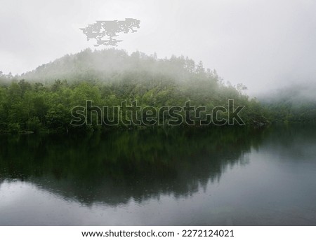 Lake with clear water covered by fog and clouds