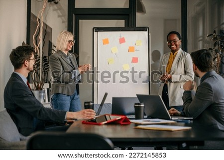 Group of business workers working together in a meeting. Two of them make presentations to colleagues at the office.