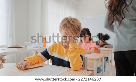 Elementary school students boy are stressing about doing their final exams in the exam room at school Royalty-Free Stock Photo #2272146289