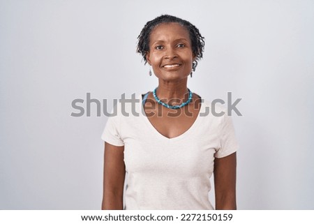 African woman with dreadlocks standing over white background relaxed with serious expression on face. simple and natural looking at the camera.  Royalty-Free Stock Photo #2272150159