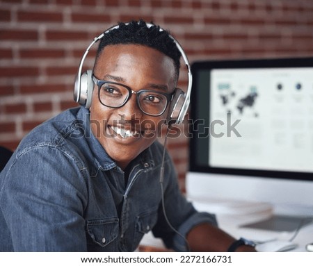 Headphones, happy and black man with a smile in office while listening to music, radio or podcast. Happiness, excited and African male employee a streaming song or playlist while working in workplace