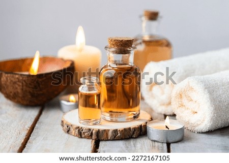 Concept of spa treatment in salon with pure organic natural oil. Atmosphere of relax, detention. Aromatherapy, candles, towel, wooden background. Skin care, body gentle treatment Royalty-Free Stock Photo #2272167105