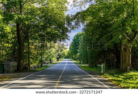 Empty two-lane asphalt road among trees, Quebec, Canada Royalty-Free Stock Photo #2272171247