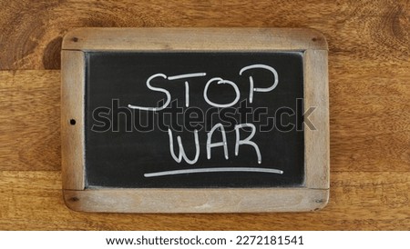 the words 'stop war' written on a slate