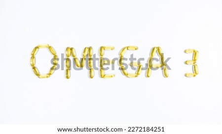 Word OMEGA 3 lined from yellow transparent capsules with fish oil.  White background. Maintaining and improving health.  Royalty-Free Stock Photo #2272184251