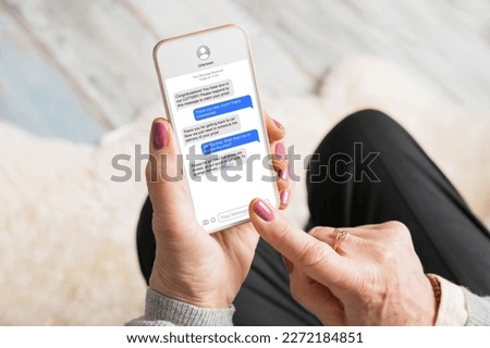 Old woman receiving scam messages on her mobile phone Royalty-Free Stock Photo #2272184851