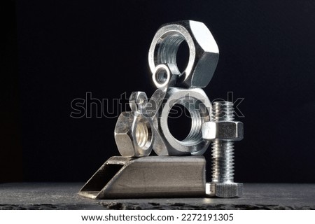 composition of nuts bolts and scraps of metal laid out on a dark background
