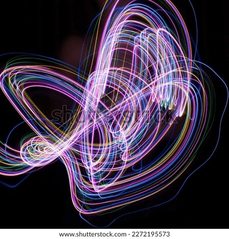 Multicolored lines on a black background. Shooting a multicolored garland in motion on a slow shutter speed.
